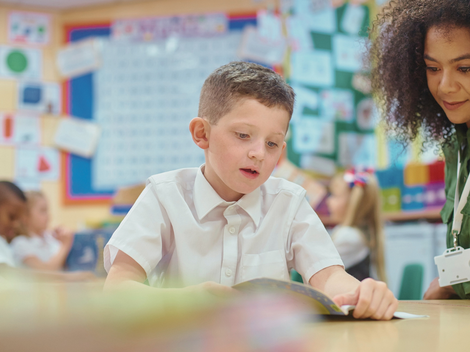 A teacher helping a primary student develop reading.