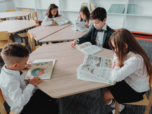 Children reading around a table at school