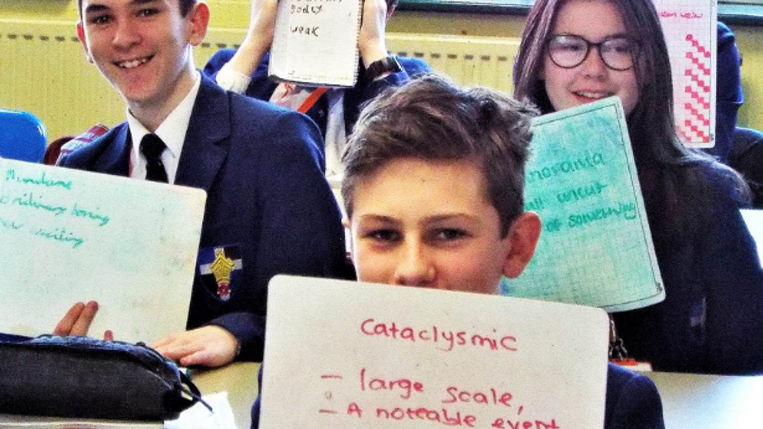Learners holding up whiteboards with Tier 2 vocabulary on